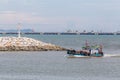 FishermanÃ¢â¬â¢s boat on the sea with industry dock in background. Royalty Free Stock Photo